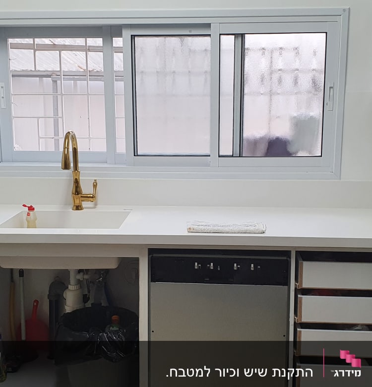 מטבח עם משטח שיש לבן וכיור מובנה